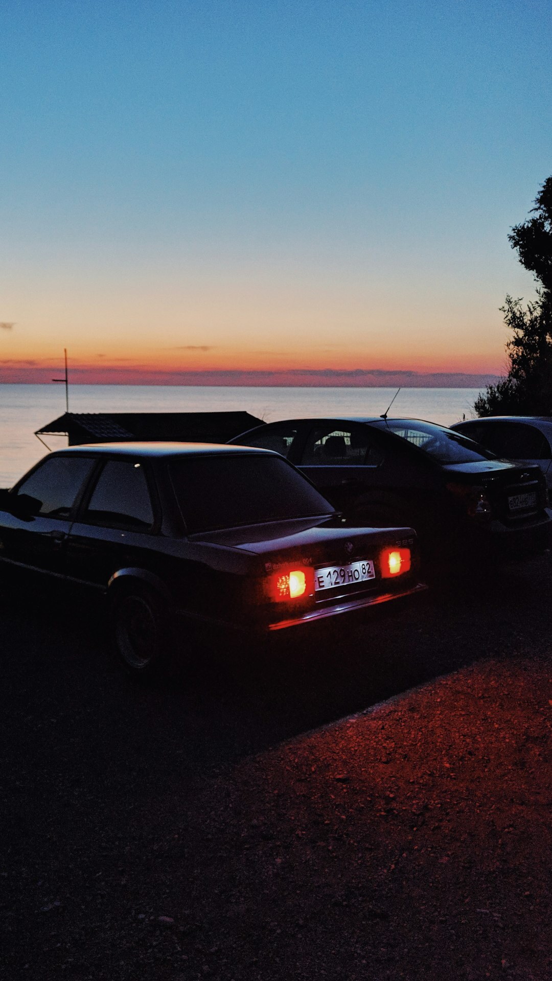 Classic sports car driving along a coastal road at sunset in Punta del Este
