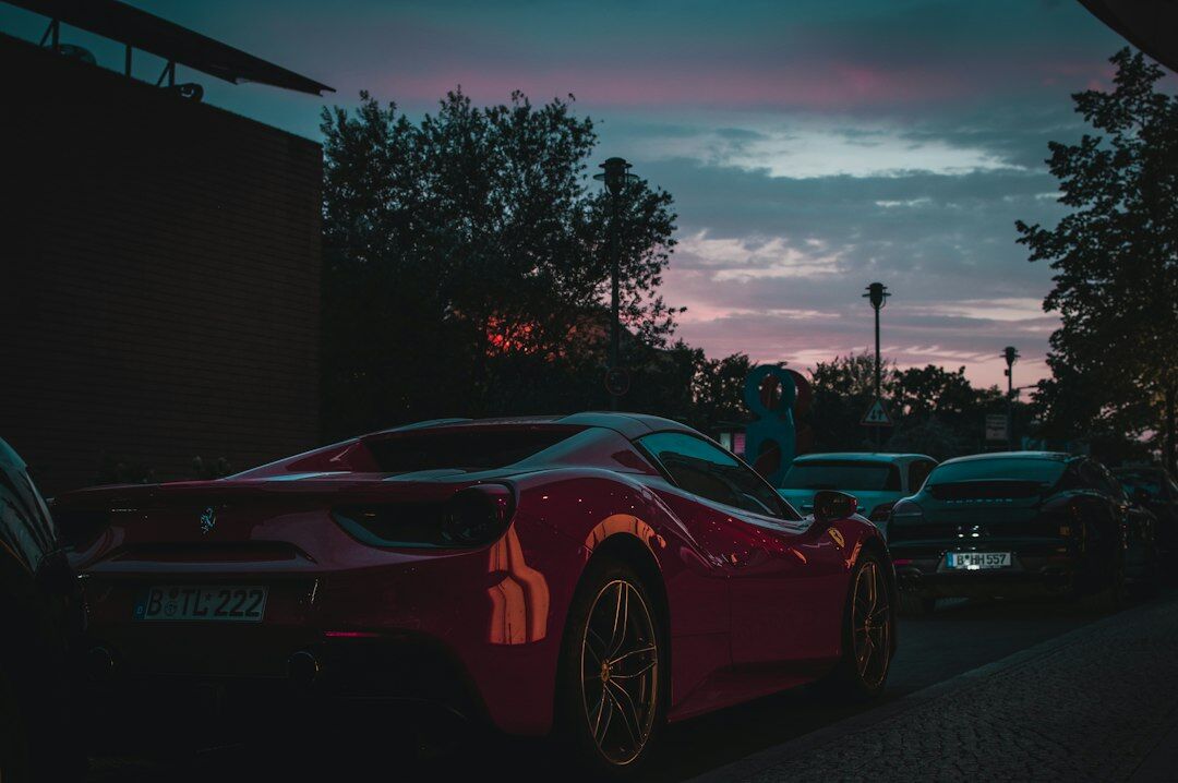 Red vintage Italian sports car parked on a Montevideo street at dusk